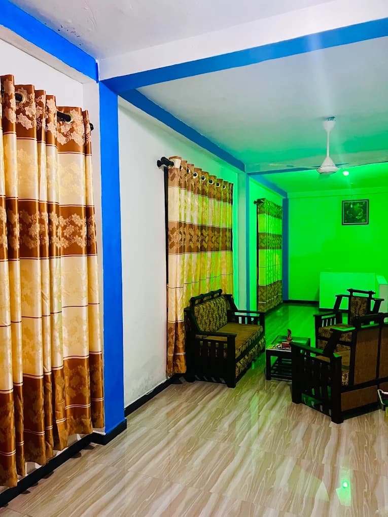 Sitting area with wooden armchairs and patterned curtains