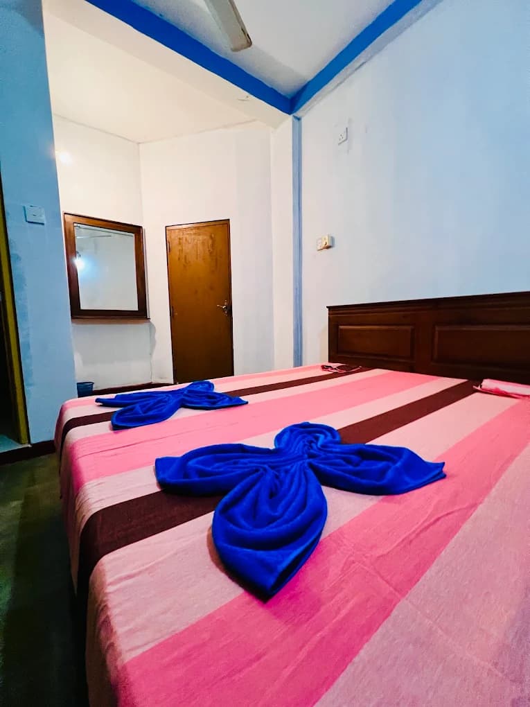 Guest room with a made bed and folded towel